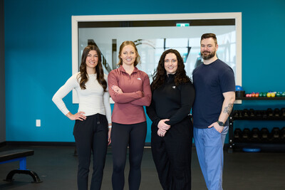 A group of four physiotherapists standing in clinic gym