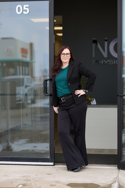 Woman standing in Nova clinic doorway wearing black jacket