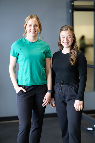 two women physiotherapist and chiropractor standing in gym setting