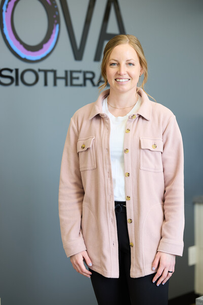 Woman wearing pink jacket standing in front of Nova sign