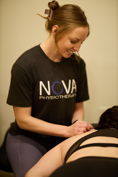 Dry needling treatment provided by physiotherapist while holding dry needle 