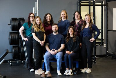 Group picture of eight team members sitting in clinic gym